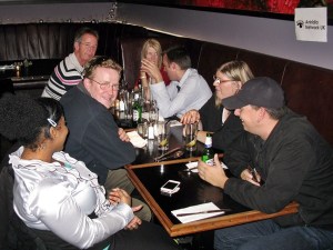 7 people sitting a table in a bar