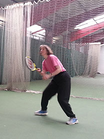 Sarah on a indoor tennis court with a racket
