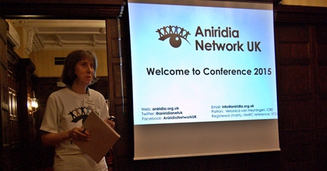 Sarah in front of projection welcoming everyone to Conference