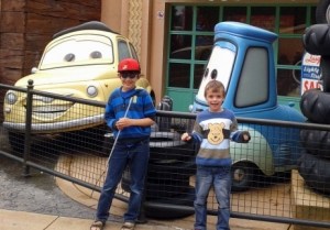 Two boys in front of characters from the film Cars