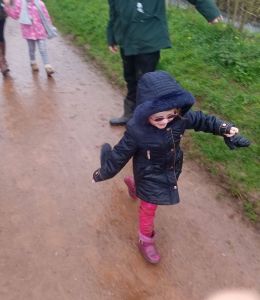 Scarlett looking happy in her dark blue coat and dark glasses as she walks along the muddy path