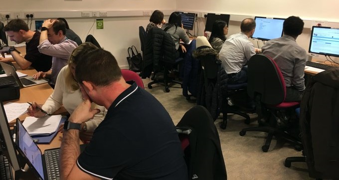 9 people sitting at 7 computers