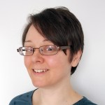 Rachel with very short brown hair and glasses