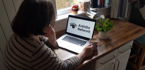 Woman at a laptop displaying a slide saying Aniridia Network Conference