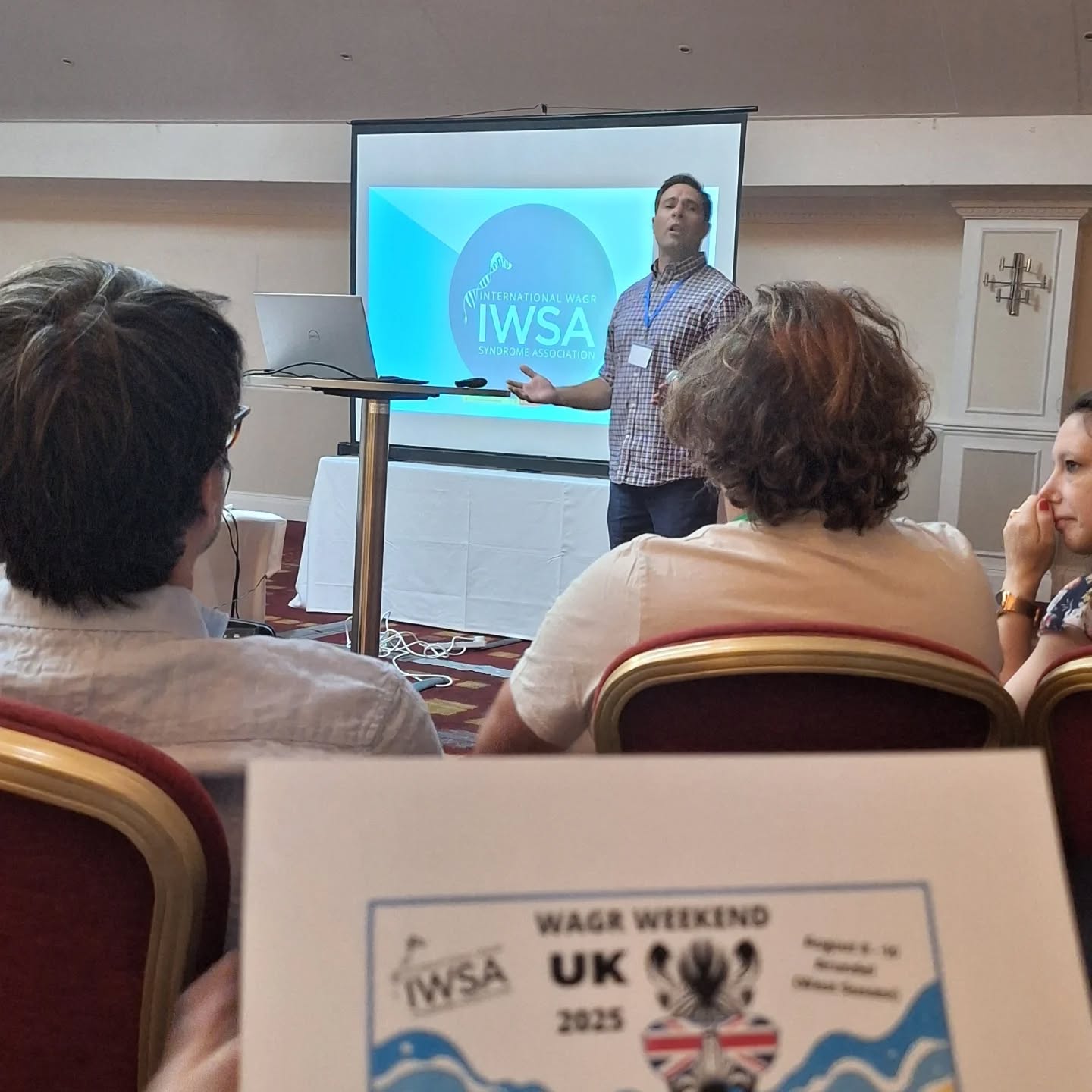 John presenting in front of IWSA logo