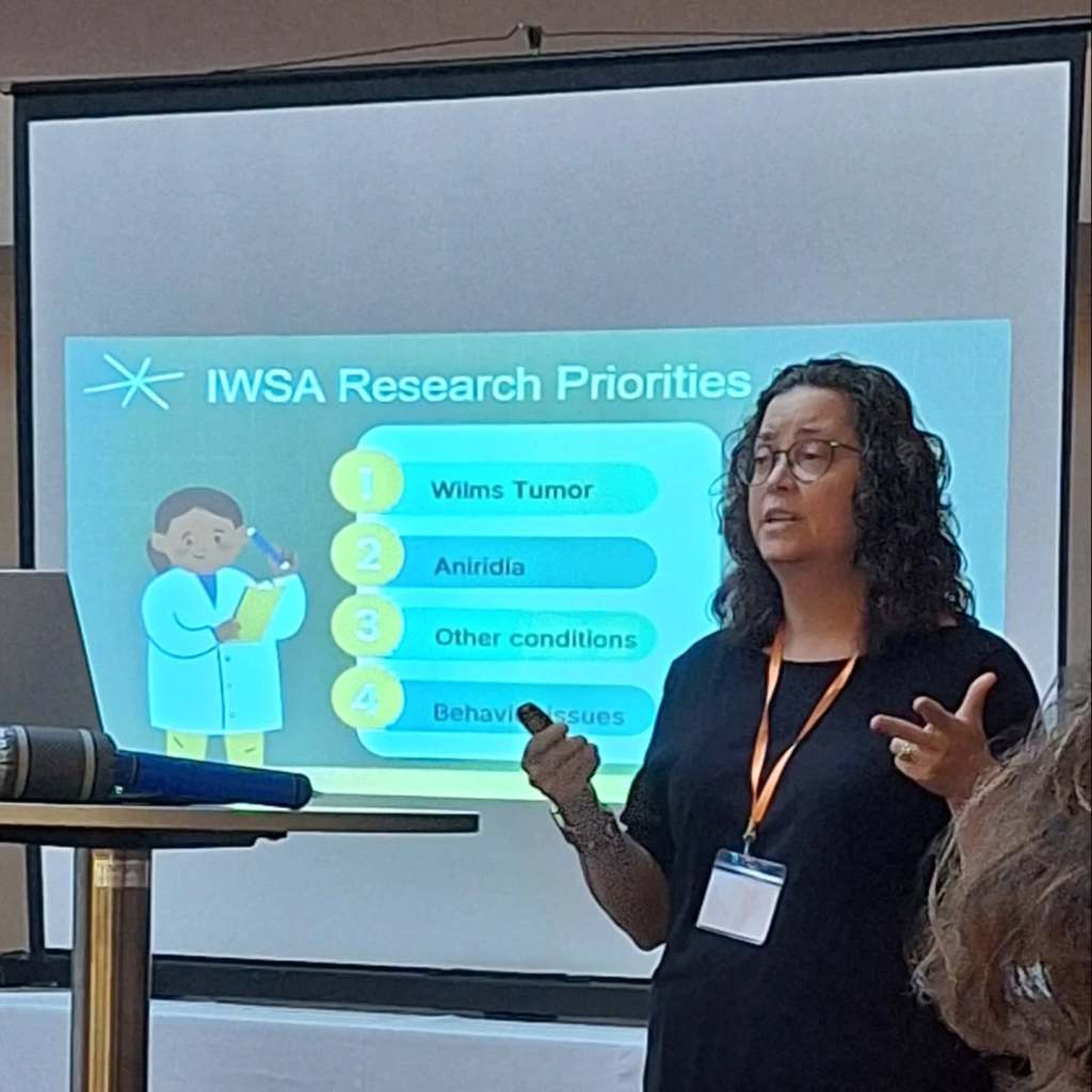 Kelly presenting in front of a projection screen