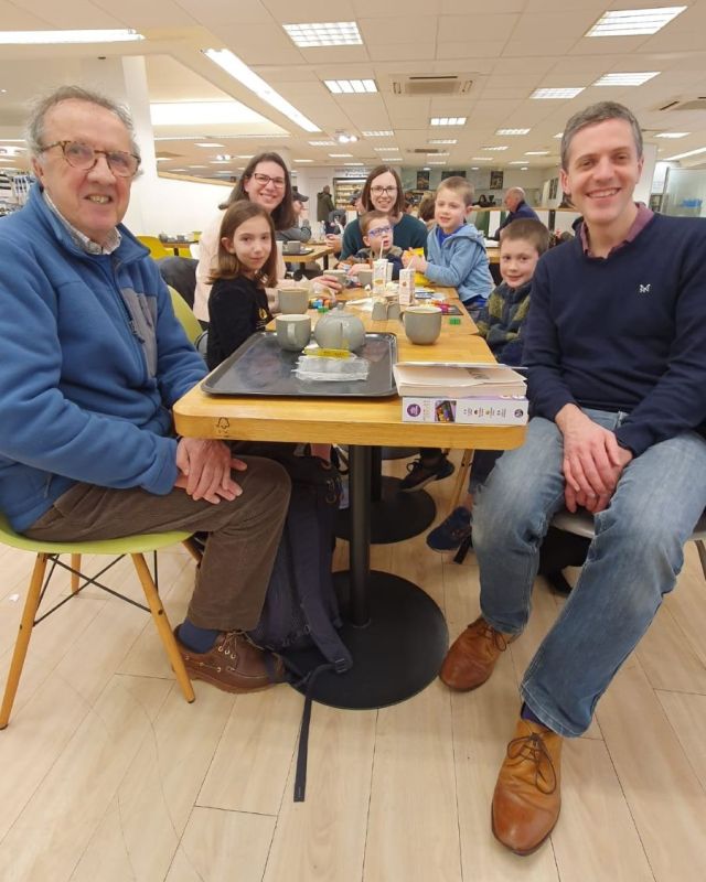 Group of mixed aged people at a cafe table looking at the camera