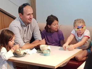 Dad and 3 children sitting at a cafe table